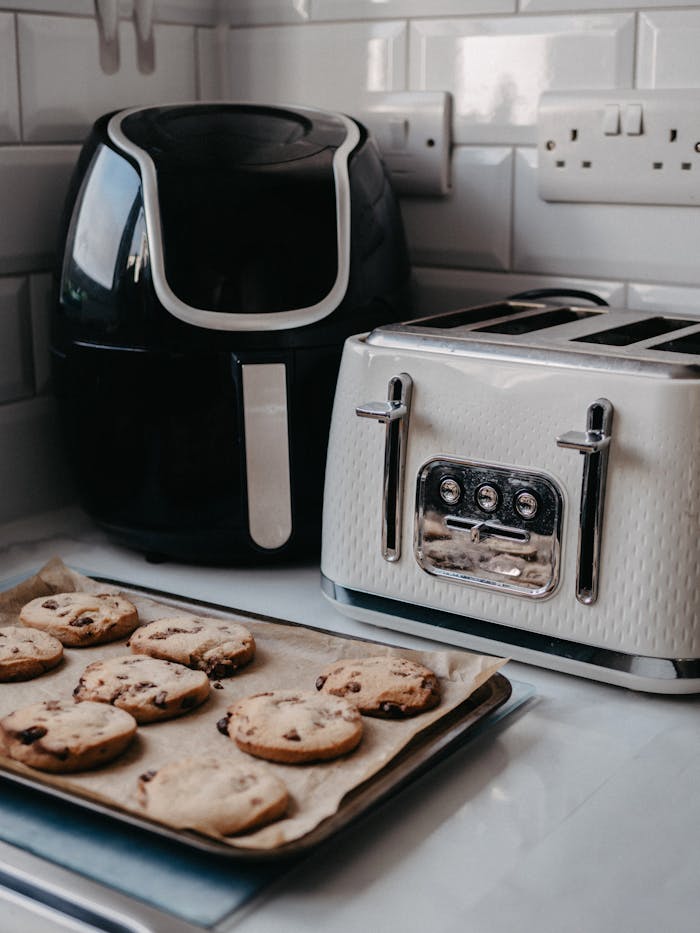 portfolio-01 Freshly baked cookies on tray beside air fryer and toaster.